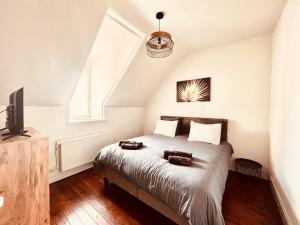 a bedroom with a bed and a tv and a window at Villa Léontine Wimereux in Wimereux