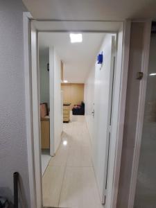 a hallway leading to a living room with a white wall at Quarto, Sala e Cozinha integrada na 116 Norte in Brasilia