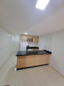 an empty kitchen with a sink and a refrigerator at Quarto, Sala e Cozinha integrada na 116 Norte in Brasilia +11 photos