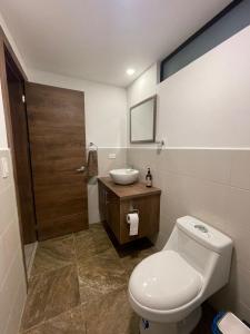 a bathroom with a toilet and a sink at Alojamiento en Ambato in Ambato +10 photos