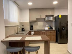 a kitchen with a table and a black refrigerator at Alojamiento en Ambato in Ambato