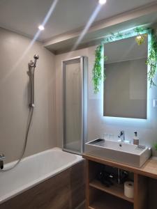 un bagno con vasca, lavandino e specchio di Jägerhotel ad Annenheim