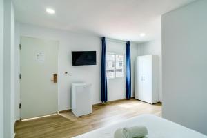 a bedroom with white walls and a bed and a mirror at Rancho Grande in Marbella