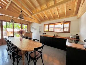 a kitchen and dining room with a wooden table and chairs at La Villa Les Inséparables in Lège-Cap-Ferret