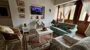 a living room with a couch and a tv at Lindo Apartamento ubicado a 3 cuadras de Plaza Mayor in Villa de Leyva