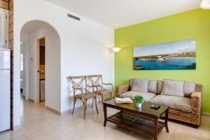 un soggiorno con un divano e un tavolo di Son Bou Playa Gold by Menorca Vacations a Son Bou