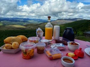 a picnic table with food and a bottle of wine at Chalés da Pedra in Lavras Novas