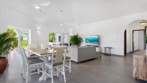een eetkamer en een woonkamer met een tafel en stoelen bij Châlet Genesis in Meads Bay