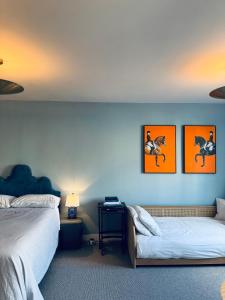 1 Schlafzimmer mit 2 Betten, einem Tisch und 2 Bildern in der Unterkunft Stunning Designer House, Fantastic City Location - Cambridge Homehost in Cambridge