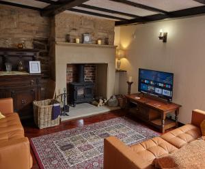 a living room with a couch and a fireplace at Keepers Cottage Serviced Accommodation Yorkshire in Sowerby Bridge
