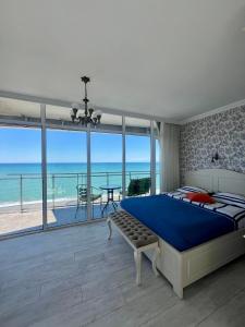 a bedroom with a bed and a view of the ocean at Apartment Batumi Weekend in Batumi