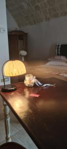 a table with a lamp and a bed in a room at Borgovecchio Suite in Ostuni
