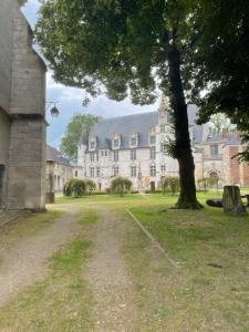 a large house with a tree in front of it at Appartement hyper-centre vue cathédrale in Beauvais