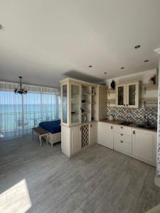 a large kitchen with white cabinets and a table at Apartment Batumi Weekend in Batumi