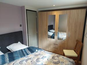 a bedroom with a bed and a cabinet with a mirror at Opeteukske in Lanaken