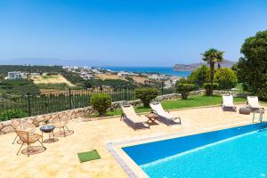 a swimming pool with chairs and a view of the ocean at Pasiphae villas 1 & 2 in Stalos