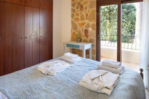 a bedroom with a bed with towels on it at Pasiphae villas 1 & 2 in Stalos +67 photos
