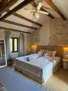 een slaapkamer met een groot bed met een plafondventilator bij NEW 2024! Casa Vecchia in Višnjan +48 foto's
