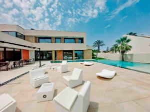 ein Haus mit weißen Möbeln und einem Swimmingpool in der Unterkunft Inmovecos Villa Gawy 2 de Lujo con piscina privada in La Manga del Mar Menor