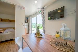 a living room with a dining room table and a bedroom at Mobile home Adria in Murter