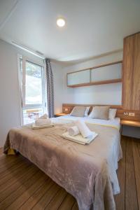 a bedroom with a large bed with towels on it at Mobile home Adria in Murter
