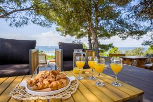 a table with a plate of bread and glasses of wine at Mobile home Adria in Murter