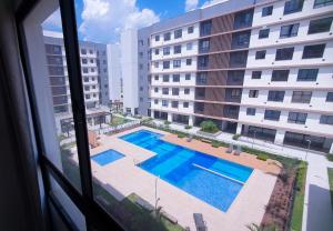 a view of a swimming pool from a window at Apto condomínio conforto e ótima localização in Lucas do Rio Verde