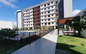 a building with a fence and a swimming pool at Apto condomínio conforto e ótima localização in Lucas do Rio Verde