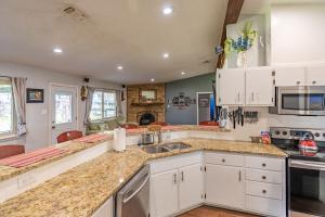 a kitchen with white cabinets and a sink at ArtLens Casa in Schertz