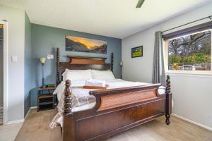 a bedroom with a wooden bed with a window at ArtLens Casa in Schertz