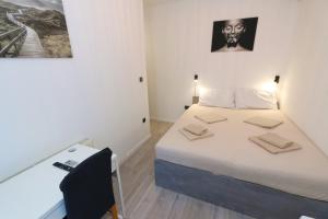 a bedroom with a bed and a desk with a chair at Pansion Comfort Sidro in Novalja