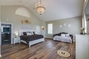 a bedroom with two beds and a chandelier at Sprawling Kentucky Getaway with Pool and Hot Tub! in Berry +37 photos