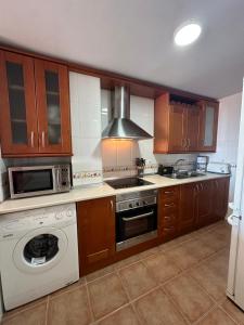 a kitchen with wooden cabinets and a stove top oven at Precioso apartamento en la Herradadura in La Herradura