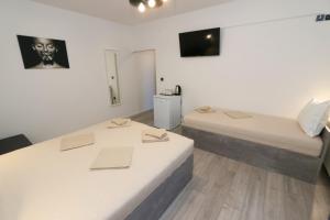 a room with two beds and a tv on the wall at Pansion Comfort Sidro in Novalja