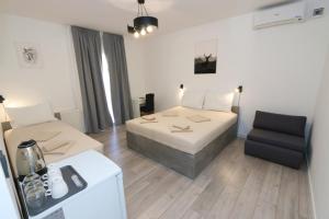 a hotel room with a bed and a chair at Pansion Comfort Sidro in Novalja