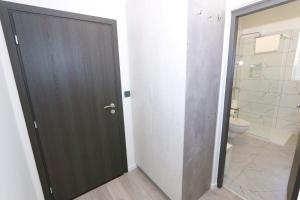 a bathroom with a black door and a toilet at Pansion Comfort Sidro in Novalja