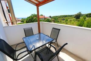 a table and chairs on a balcony with a view at Pansion Comfort Sidro in Novalja