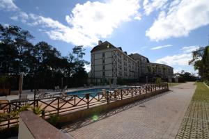 ein Gebäude mit einem Swimmingpool vor einem Gebäude in der Unterkunft Vista Azul Apart Hotel - Suite Vista Pedra Azul in Pedra Azul