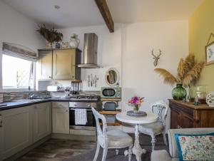 Una cocina con una mesa y sillas en una habitación. en Hen Gilfach Stable, en Llanrhwydrys