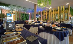 a banquet hall with blue tables with food on them at Hotel Albaida Nature in Mazagón