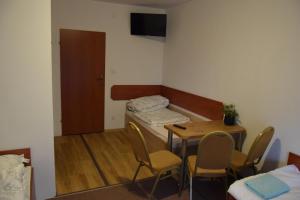 a room with a table and a bed and a table and chairs at Apartament Czos Przy S16 in Mrągowo