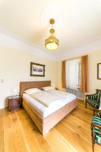 a bedroom with a large bed and a chandelier at Villa Thalhof in Bad Gleichenberg