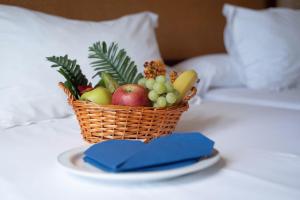 a basket of fruit on a plate on a bed at Hotel Albaida Nature in Mazagón