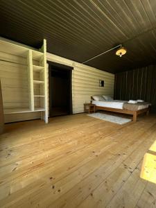 an empty room with a bed and a wooden floor at Відпочинковий комплекс Біла Кобила in Verkhovyna
