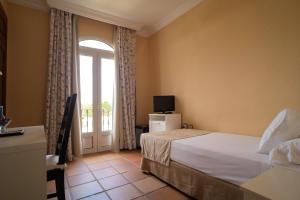 a hotel room with a bed and a window at Hotel Albaida Nature in Mazagón