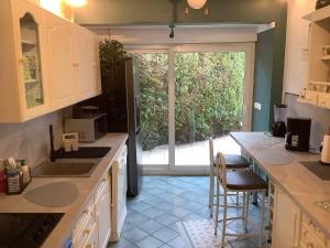 a kitchen with a counter and a large window at Location JO 2024 Chambre d'hôte Petit déjeuner offert in Torcy