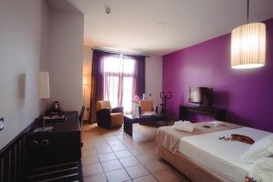 a hotel room with a bed and a purple wall at Hotel Albaida Nature in Mazagón