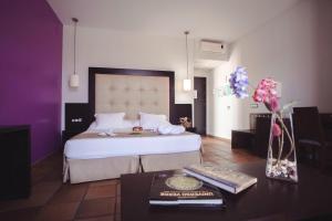 ein Schlafzimmer mit einem großen Bett und einem Tisch mit Tastatur in der Unterkunft Hotel Albaida Nature in Mazagón