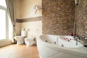 a bathroom with a bath tub and a toilet at Hotel Albaida Nature in Mazagón
