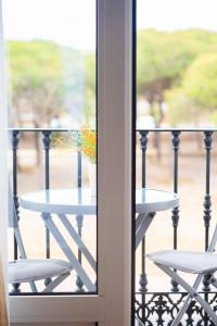 a table on a balcony with a vase on it at Hotel Albaida Nature in Mazagón
